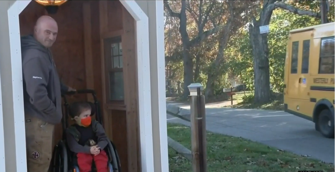 Ryder Kilam with his dad inside a sheltered bus stop shed constructed by the Construction Technology class at Westerly High School, Photo Credit: Click On Detroit | Local 4 | WDIV/Youtube