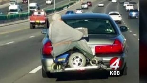 Photo Of Man Strapped To Back Of Car Goes Viral (Video) Promo Image