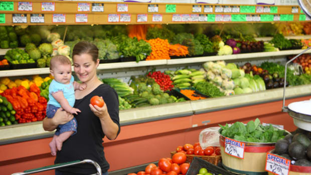 Woman grocery shopping with baby