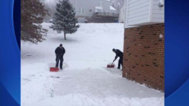 Police officers shoveling snow 