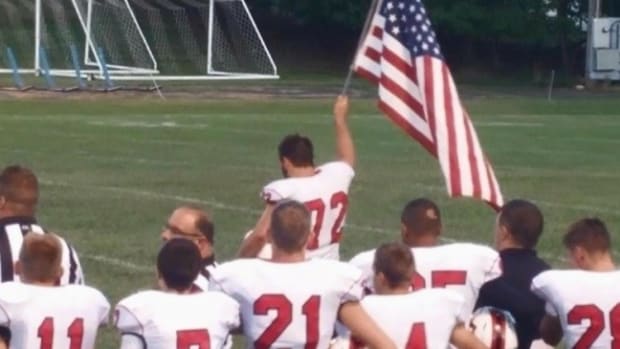 High School Football Player Brings Flag Onto Field Promo Image
