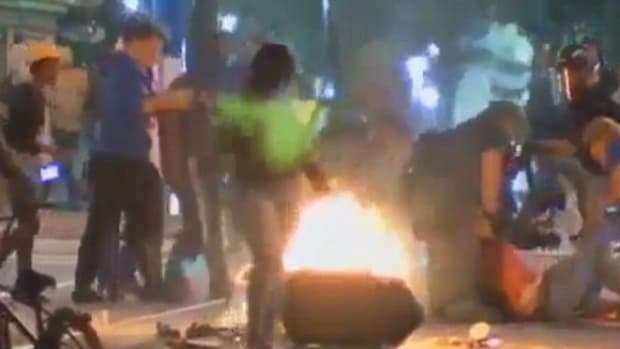 Rioters Beat Man, Almost Push Reporter In Fire (Video) Promo Image