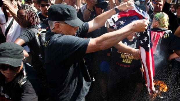 Protesters Burn American Flag Outside Of RNC (Photos) Promo Image