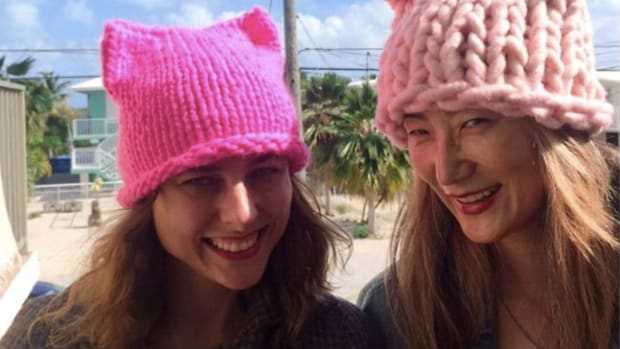 Here's Why Women Are Wearing Pink Knit Cat-Eared Hats Promo Image