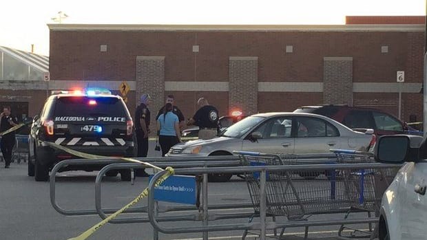 Investigators and police officers speak near car where baby was found in Walmart parking lot