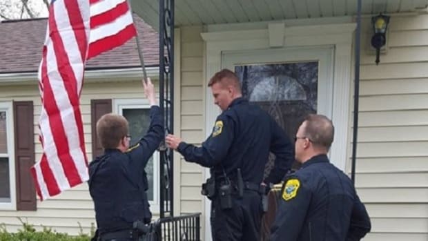 Police Officers Replace Elderly Widow's Stolen Flag Promo Image