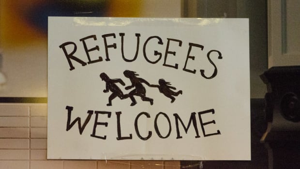 A sign welcoming asylum-seeking refugees