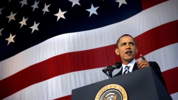 president obama speaking in front of american flag backdrop