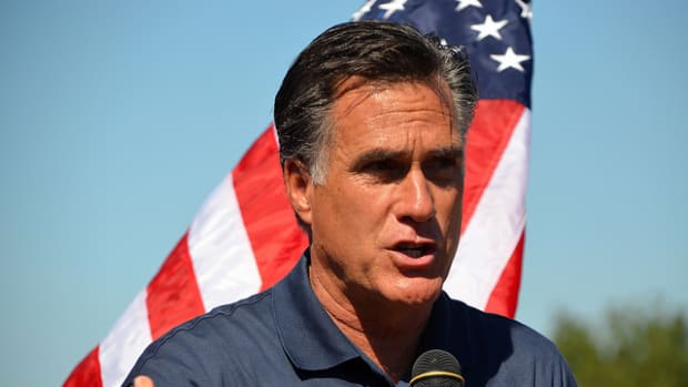 Mitt Romney Speaking In Front Of Flag