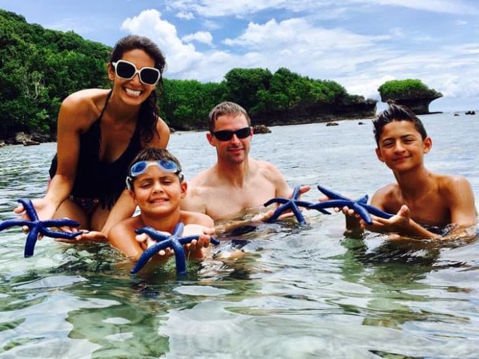 Tania Duenas Sweeney in the ocean with her family holding starfish, Photo Credit: Facebook/Tania Duenas Sweeney