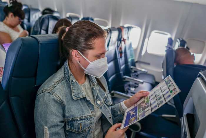 Woman in a denim jacket sitting inside a Plane, Photo Credit: Pexels