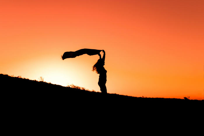 A Silhouette of a Woman Holding a Cloth during "Golden Hour," Photo Credit: Pexels