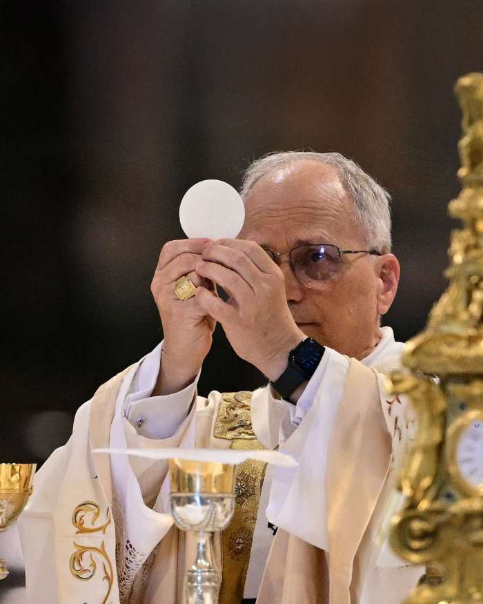 Pope Leo XIV elevating the Body of Christ in a mass wearing a fitness watch, Photo Credit: cassie/X