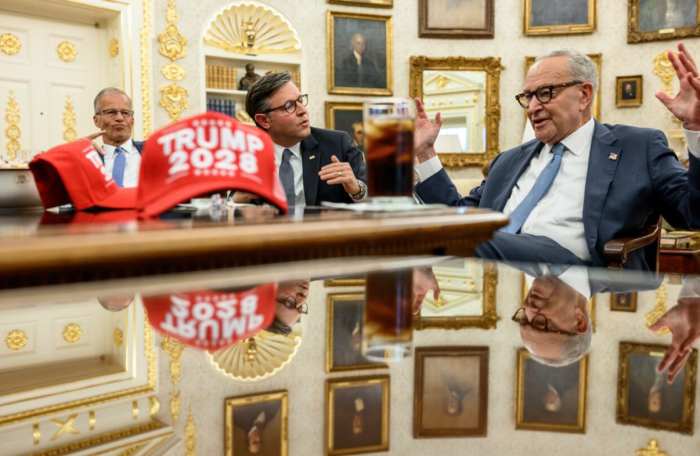 A Trump 2028 hat on the desk with House Speaker Mike Johnson, Senate Minority Leader Chuck Schumer, Photo Credit: Politics & Poll Tracker/X