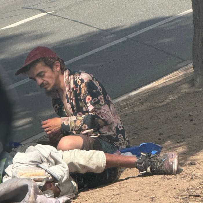 Tylor Chase sitting on the ground in the streets of LA, Photo Credit: CHOQUEI/X
