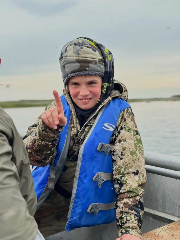Spencer Trump wearing a camouflage outfit while riding a boat, Photo Credit: donaldjtrumpjr/Instagram