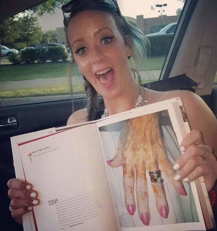 Brandalyn Mae Porter smiling while holding a book open to a page of a close-up of an elderly woman's hand, Photo Credit: Brandalyn Mae Porter/Facebook