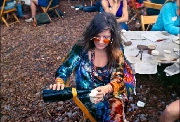 Janis Joplin pouring a drink backstage at Woodstock, August 1969, Photo Credit: Classic Rock In Pics/X