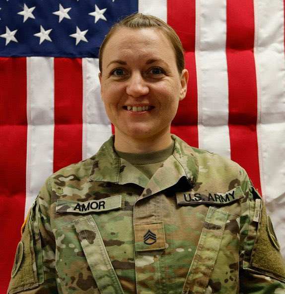 Sgt. 1st Class Nicole Amor wearing a U.S. army uniform with American flag in the background, Photo Credit: Military Support/X