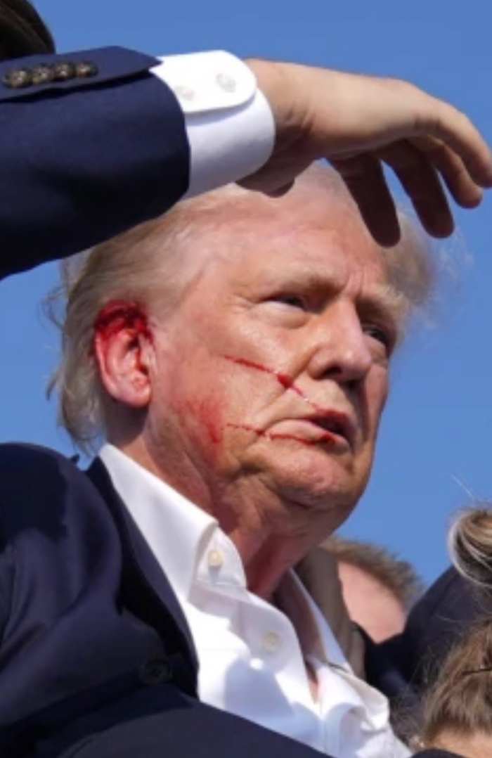 President Donald Trump with blood on his right ear and cheek following a shooting incident at a campaign rally in Butler, Pennsylvania, 2024, Photo Credit: DramaAlert/X