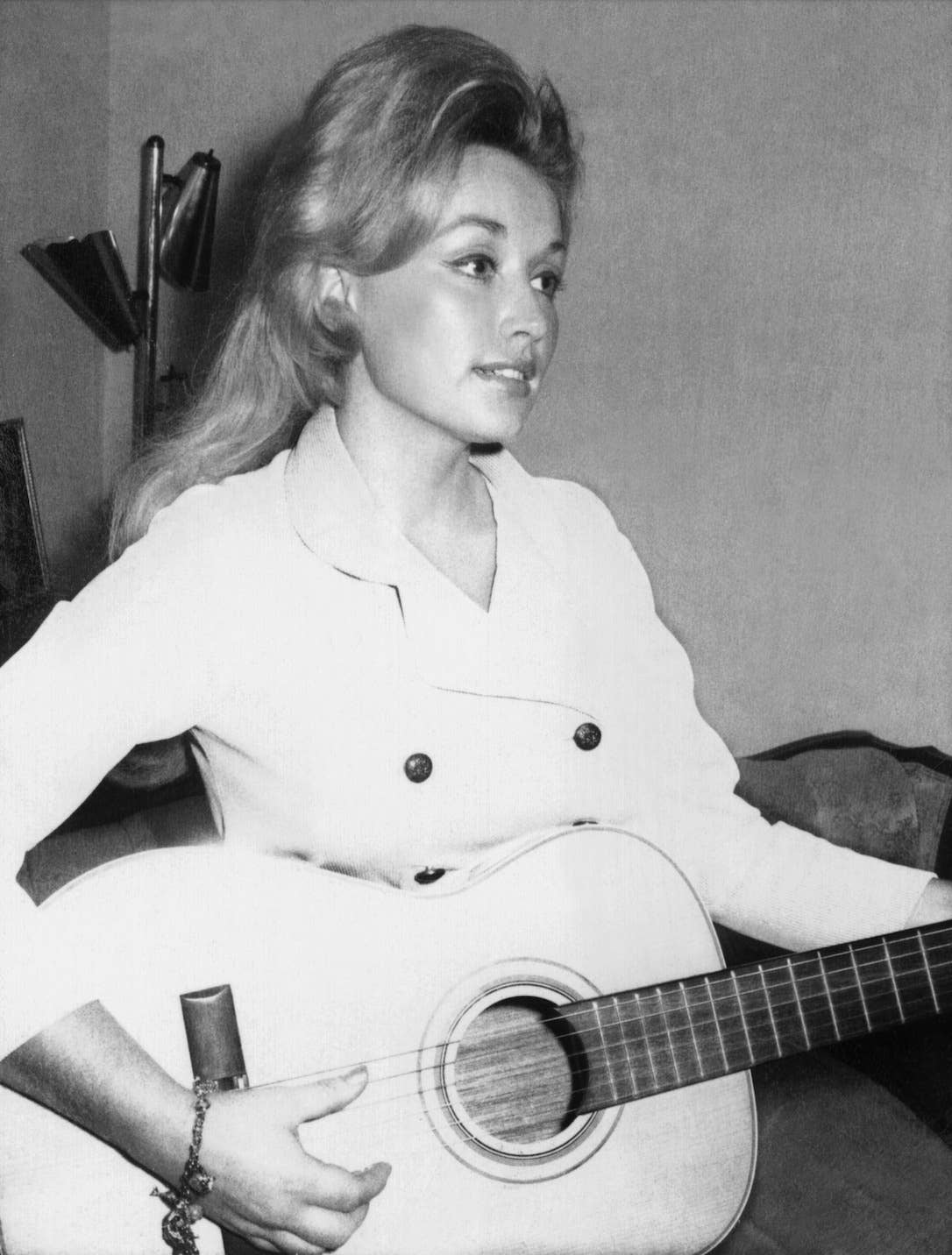 A 20-year-old Dolly Parton holding an acoustic guitar in a recording studio in 1966, Photo Credit: Dolly Parton/Facebook