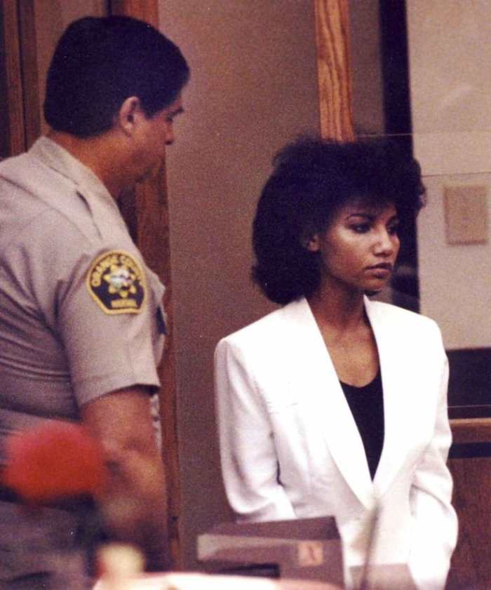 Omaima Nelson escorted by a police officer while entering a courtroom, Photo Credit: Harvey Specter/Xander Xavier/X