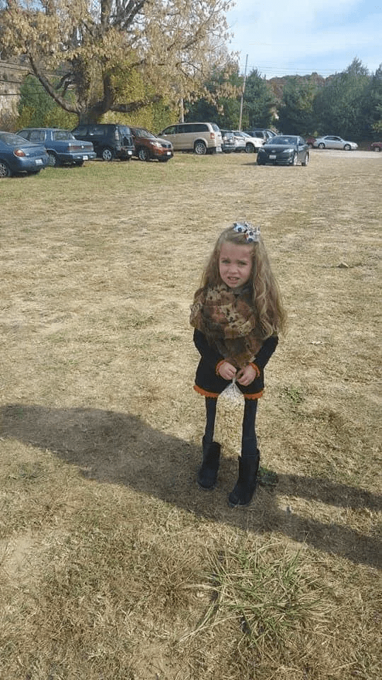 Viral image of a little girl standing on grass where her legs look extremely skinny but that's only because she's holding a bag of popcorn which creates an optical illusion, Photo Credit: BIG 101/Facebook