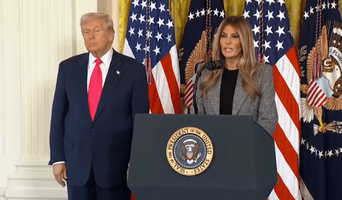 President Donald Trump standing beside his wife giving a speech, Photo Credit: Aaron Rupar/X