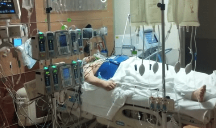 A man lying down in an ICU bed at a Hospital, Photo Credit: Your Living Manna/Youtube