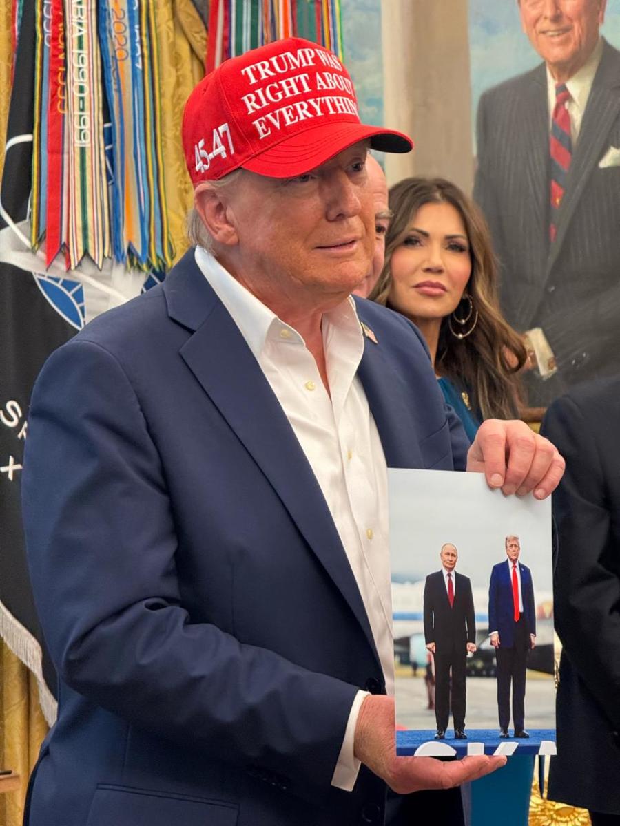 US President Donald Trump holding a photo of him and Russian President Vladimir Putin during their meeting in Alaska, Photo Credit: Alexander Joseph S Babao/X