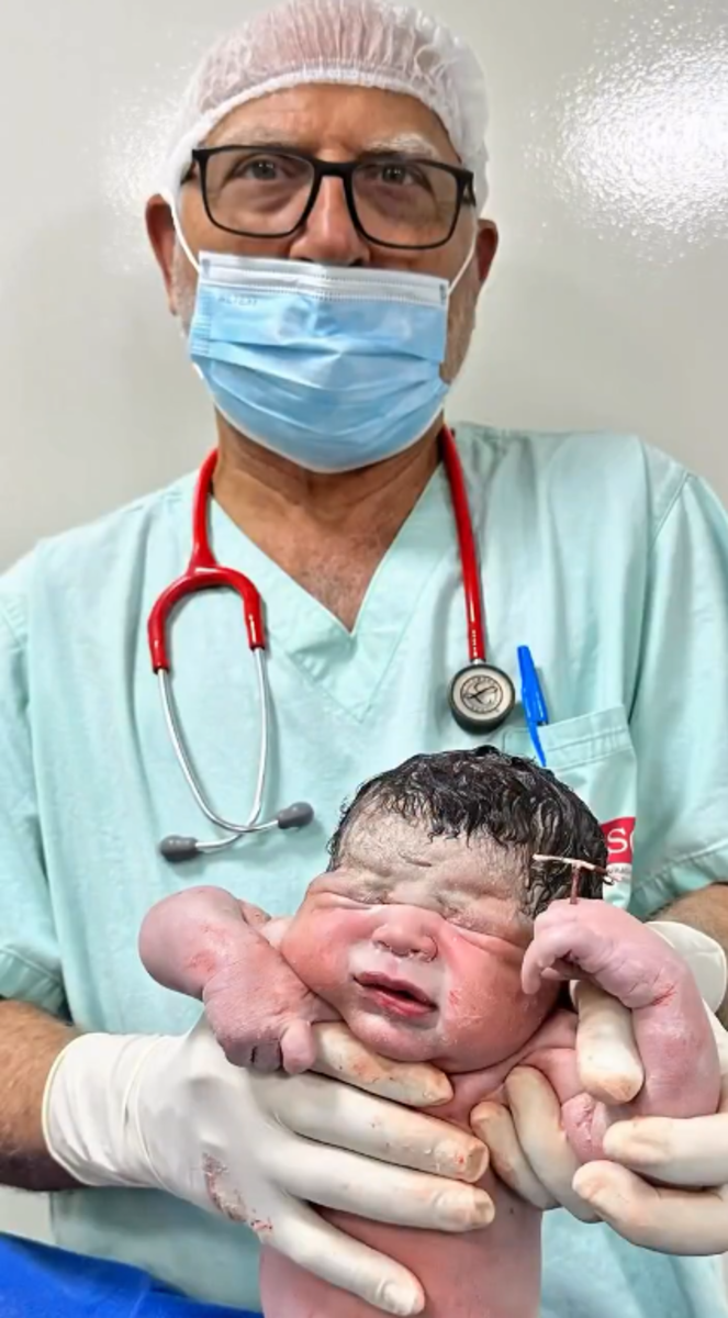 A newborn baby holding an IUD in his hands, Photo Credit: Governo de Goiás/X