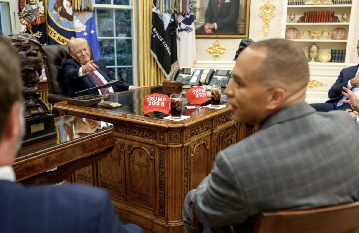 President Donald Trump sat at his desk in the Oval Office with "Trump 2028" hats visible, Photo Credit: Politics & Poll Tracker/X