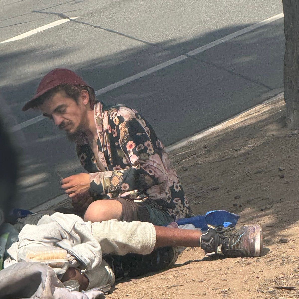 Tylor Chase sitting on the ground in the streets of LA, Photo Credit: CHOQUEI/X