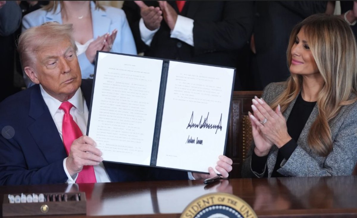 President Trump holding up a signed executive order next to his wife Melania, Photo Credit: louis daniel/X