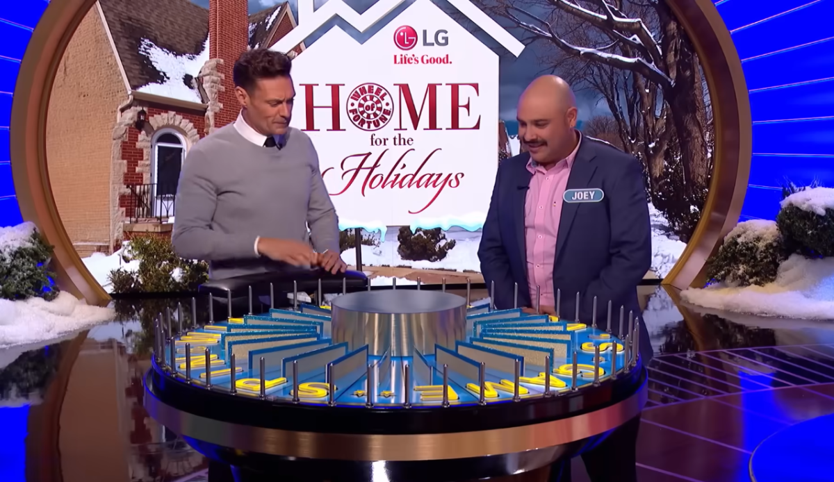 Host Ryan Seacrest standing over the spin the wheel with Contestant Joey Sweet, Photo Credit: Wheel of Fortune/Youtube