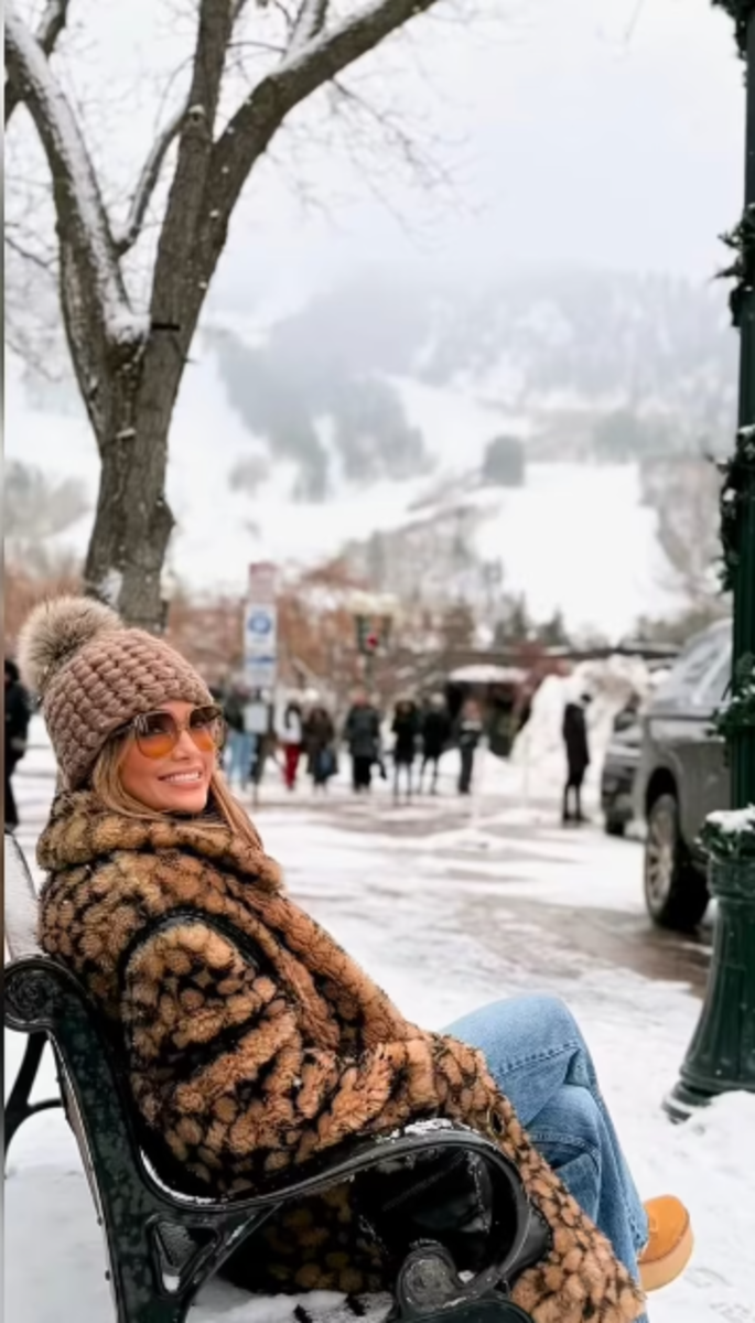 Jennifer Lopez sitting on a bench in the snow, Photo Credit: jlo/Instagram