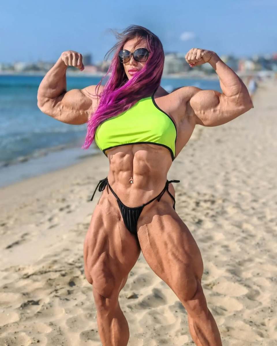 Natalia Kuznetsova flexing for the camera on a beach, Photo Credit: nataliya.amazonka/Instagram