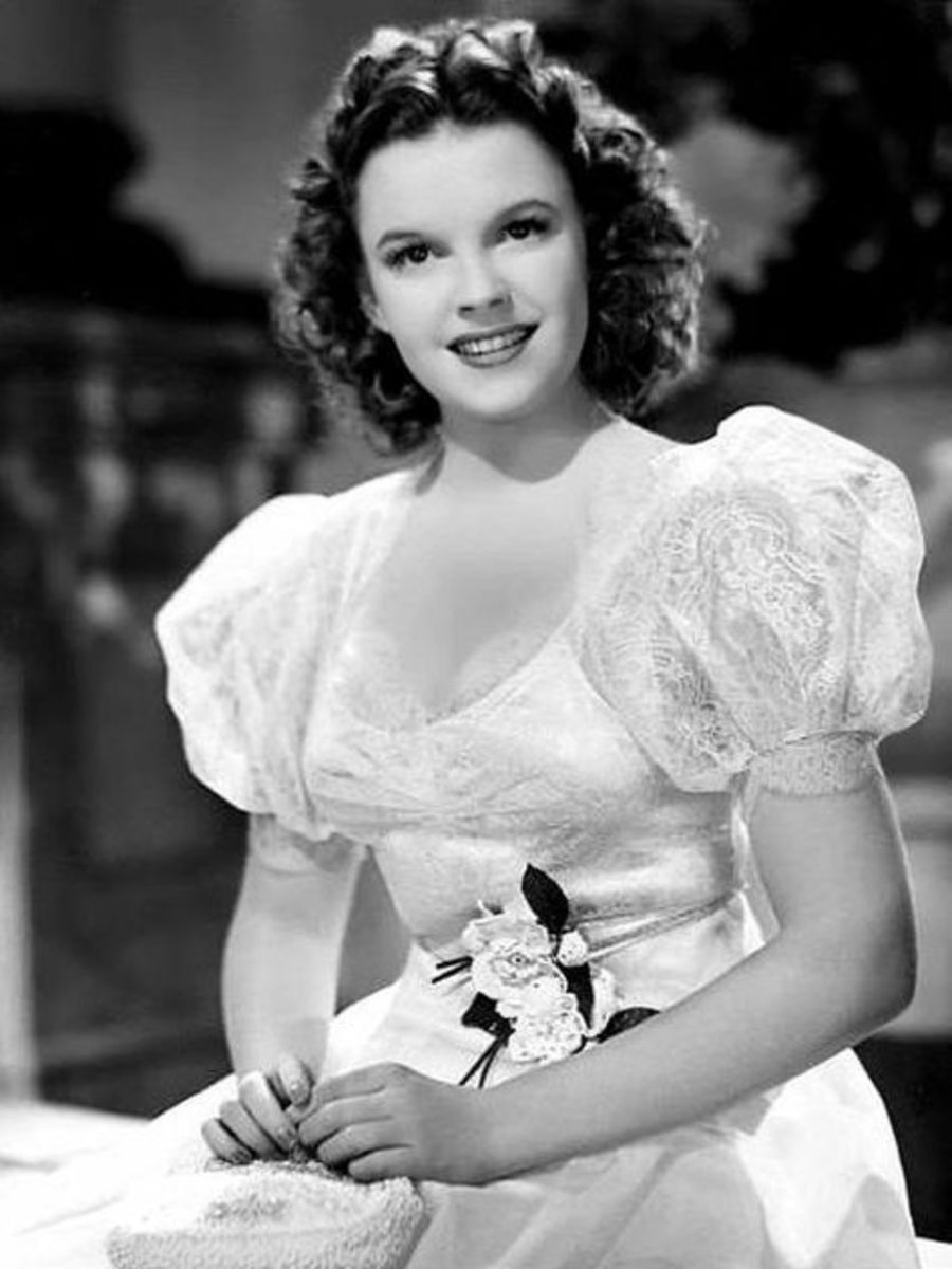 Judy Garland in the movie Andy Hardy Meets Debutante wearing a white dress smiling, Photo Credit: Sherrel Higbie/X
