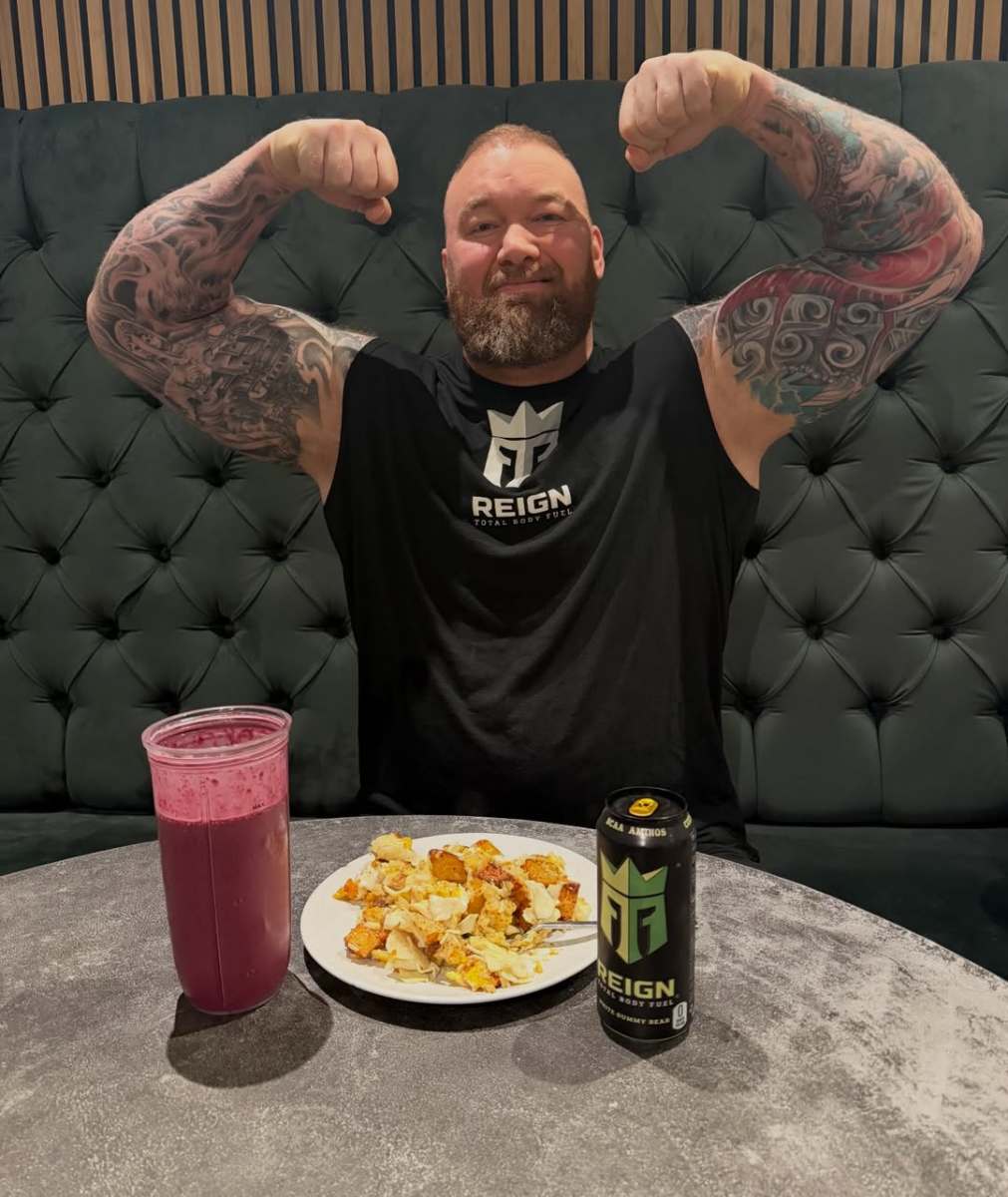 Hafthor Julius Bjornsson flexing his muscles at a table with his breakfast, Photo Credit: thorbjornsson/Instagram
