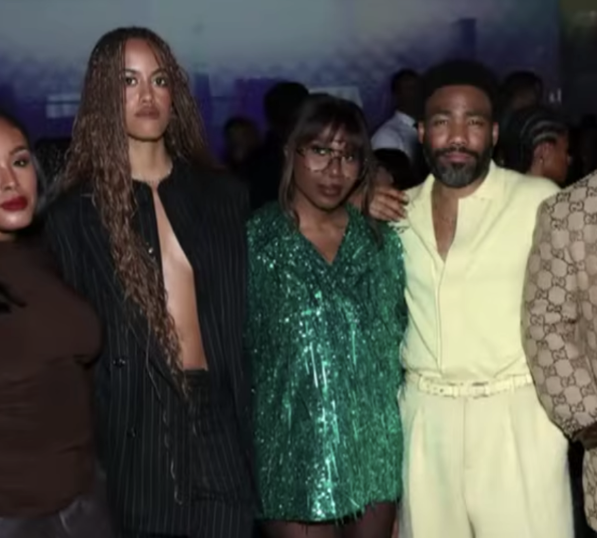 Malia Ann, formerly known as Malia Obama, posing with Childish Gambino and others at an event, Photo Credit: Entertainment Tonight/Youtube