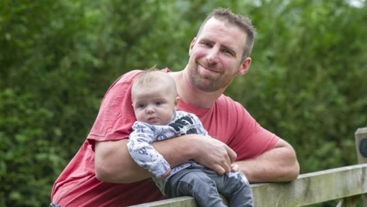 Dan Sheldon holding his son Lucifer in an outdoor area, Photo Credit: hurumacharles/Instagram